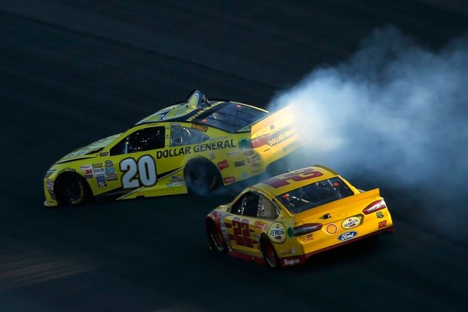 KANSAS CITY, KS - OCTOBER 18:  Matt Kenseth, driver of the #20 Dollar General Toyota, spins as Joey Logano, driver of the #22 Shell Pennzoil Ford, races by during the NASCAR Sprint Cup Series Hollywood Casino 400 at Kansas Speedway on October 18, 2015 in Kansas City, Kansas.  (Photo by Todd Warshaw/Getty Images)