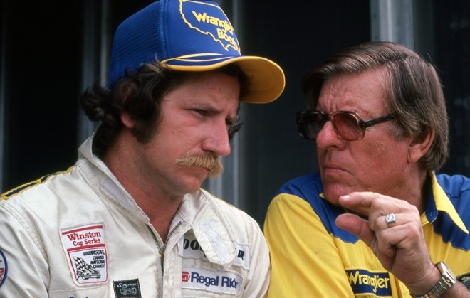 DAYTONA BEACH, FL - JULY 4:  Driver Dale Earnhardt confers with car owner Bud Moore before the Firecracker 400 race on July 4, 1982 at the Daytona International Speedway in Daytona Beach, Florida. (Photo by Dozier Mobley/Getty Images)