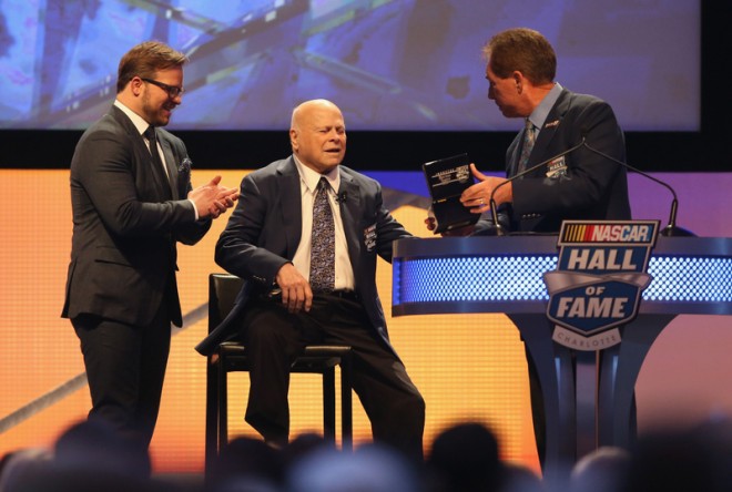 CHARLOTTE, NC - JANUARY 23: (L-R) Marcus Smith watches as his father, Bruton Smith, is inducted into the NASCAR Hall of Fame by Darrell Waltrip during the NASCAR Hall of Fame Induction Ceremony on January 23, 2016 in Charlotte, North Carolina. (Photo by Streeter Lecka/NASCAR via Getty Images)